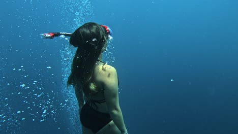 free-diver-girl-going-up-in-slowmotion-medium-shot,-scenic-apnea-diving-in-Indonesia