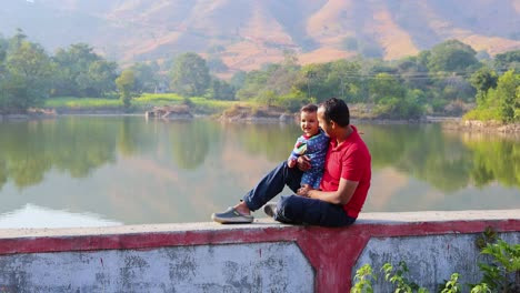 isolated-young-father-and-son-enjoying-nature-at-morning-with-blurred-background