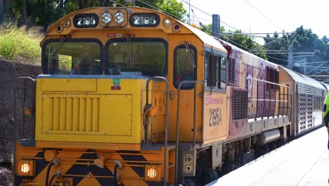 Una-Locomotora-Diésel-Amarilla-De-Queensland-Rail,-Tren-2195a,-Clase-2170,-Propiedad-De-QR,-Pasando-Por-El-Andén-De-La-Estación.