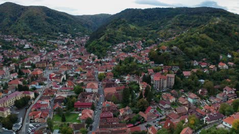 Charming-aerial-view-of-a-small-town-nestled-in-a-valley-surrounded-by-lush-green-hills