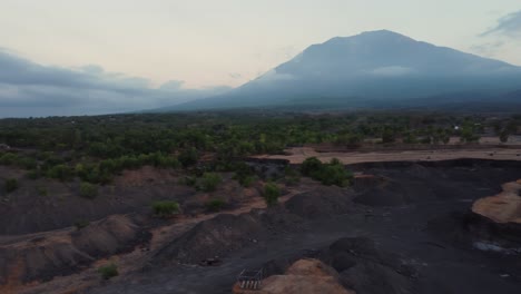 Aerial-view-construction-area-to-lush-green-forest-mountain-background