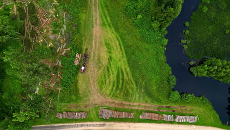 Woodcutters-preparing-logs-to-be-transported,-aerial-top-down-view