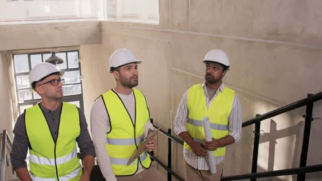 Builder-in-Helmet-with-Clipboard-Walking-Upstairs