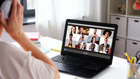 remote-job,-technology-and-people-concept--young-businesswoman-with-laptop-computer-and-papers-working-at-home-office-and-having-video-conference