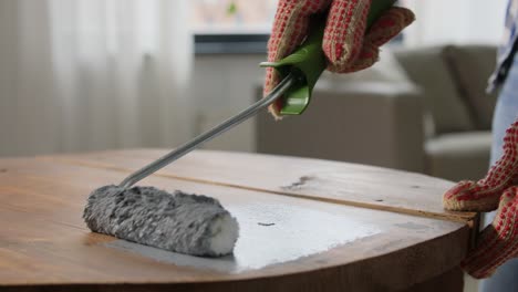 Hands-Painting-Old-Wooden-Table-with-Grey-Color