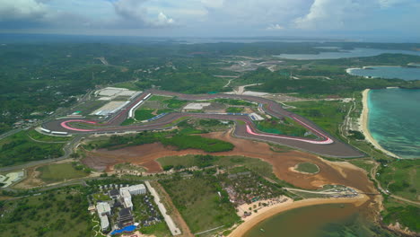 Circuito-De-Mandalika-En-Lombok-Con-Un-Exuberante-Paisaje-Verde-Y-Fondo-Costero,-Vista-Aérea