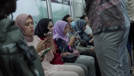 Inside-electric-train,-passengers-play-with-their-cell-phones