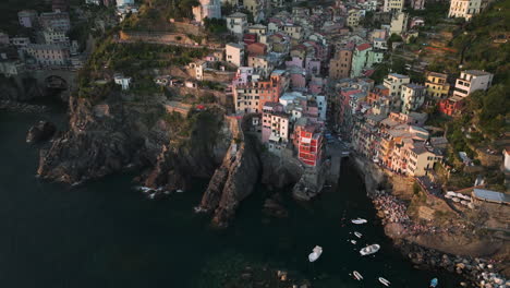 Riomaggiore-village-with-colorful-houses-on-cliffs-at-sunset,-aerial-view