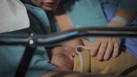 Mother-breastfeeding-her-newborn-baby-in-hospital-bed