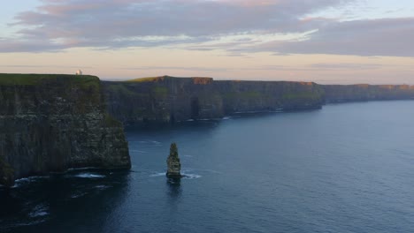 Stunning-establishing-aerial-shot-capturing-the-Cliffs-of-Moher-bathed-in-beautiful-sunset-light