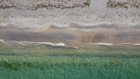 Waves-gently-lap-the-shoreline,-creating-a-serene-and-peaceful-beach-scene