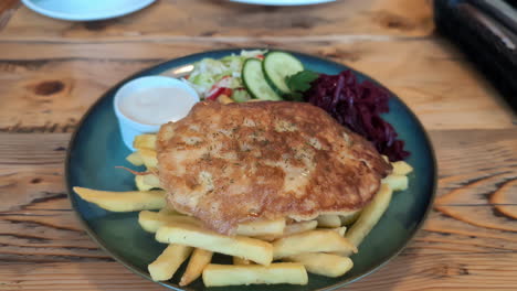 Delicious-minced-meat-steak-with-fries-on-wooden-table,-close-up