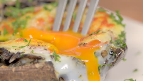 Close-up-splitting-stuffed-and-gratin-portobello-mushrooms-from-above,-with-fork-and-knife