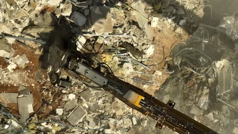 Excavator-arm-demolishing-an-old-building,-Aerial-view