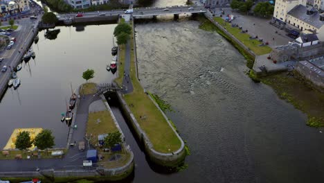 Aerial-dynamic-shot-of-Galway-city-center-during-the-arts-festival,-showcasing-Claddagh-Basin,-Spanish-Arch,-and-the-River-Corrib