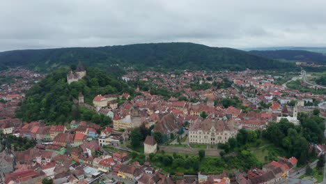 Charming-aerial-view-of-a-European-village-with-colorful-rooftops-surrounded-by-lush-green-hills