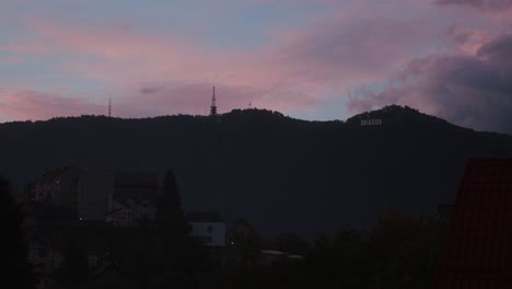 Colorful-sunset-sky-over-a-mountain-with-buildings-in-the-foreground