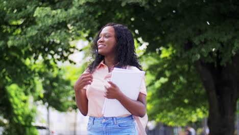 Concepto-De-Educación,-Escuela-Y-Personas-Feliz-Sonriente-Estudiante-Afroamericana-Con-Cuadernos-En-La-Ciudad