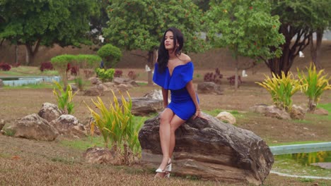 A-girl-in-a-blue-dress-takes-in-the-sun-at-a-park-on-Trinidad,-in-the-Caribbean