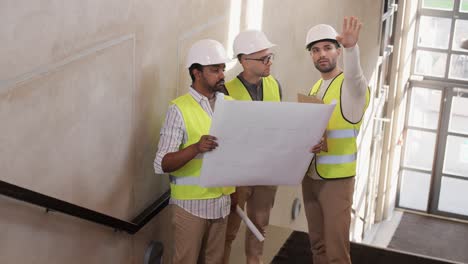 Constructor-Masculino-En-Casco-Con-Plano-En-La-Ventana