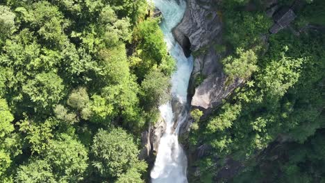 Drone-view-of-a-turquoise-waterfall-with-a-strong-current-in-Vallemaggia,-Ticino,-Switzerland