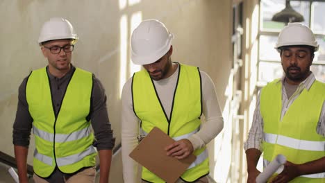 Builder-in-Helmet-with-Clipboard-Walking-Upstairs