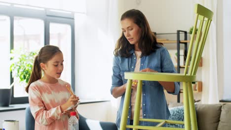 Concepto-De-Familia,-Bricolaje-Y-Mejoras-Para-El-Hogar-Feliz-Madre-Sonriente-E-Hija-Con-Regla-Midiendo-Una-Vieja-Silla-De-Madera-Para-La-Renovación-En-Casa