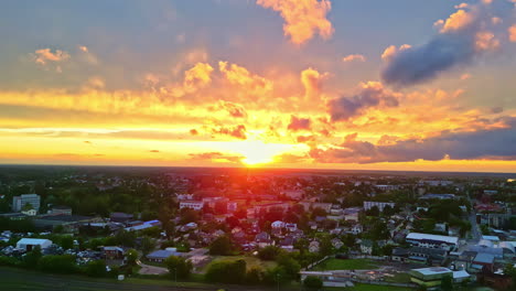 Farbenfroher-Sonnenuntergang-Mit-Drohnenblick-über-Wohngebiet,-Feurig-Gelber-Himmel-Und-Wolken