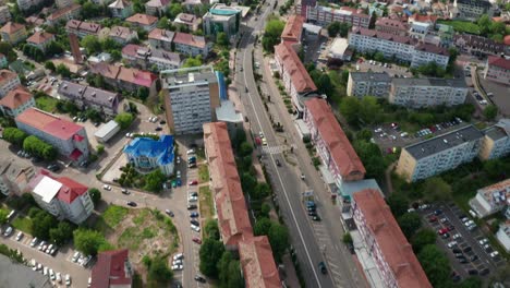 A-vibrant-cityscape-with-buildings,-roads,-and-lush-greenery-on-a-sunny-day,-aerial-view