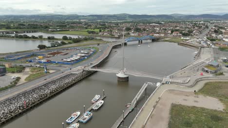 An-aerial-view-of-the-of-the-Foryd-Road-Bridge-and-Pont-y-Ddraig-Harbour-Bridge-in-Denbighshire,-Wales,-on-an-overcast-day