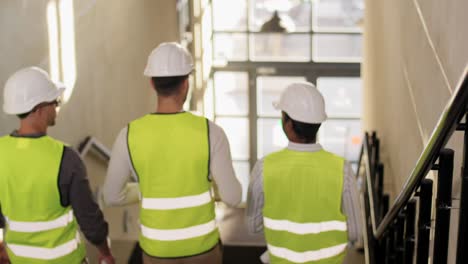 Architekten-Mit-Helmen-Gehen-Im-Büro-Die-Treppe-Hinunter