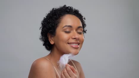 beauty-and-people-concept--portrait-of-happy-smiling-young-african-american-woman-with-bare-shoulders-touching-her-face-over-grey-background