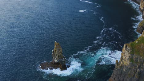 Aerial-view-pulls-back-and-ascends-from-sea-stack-at-Cliffs-of-Moher