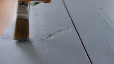 Hands-Painting-Old-Wooden-Table-with-Grey-Color