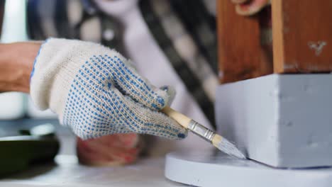 Concepto-De-Renovación,-Bricolaje-Y-Mejoras-Para-El-Hogar-Padre-E-Hijo-En-Guantes-Con-Rodillo-De-Pintura-Pintando-Una-Vieja-Mesa-De-Madera-En-Color-Gris-En-Casa