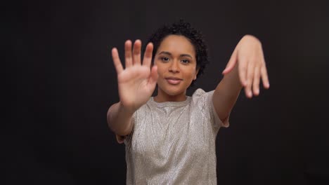 leisure-and-people-concept--happy-african-american-woman-dancing-over-black-background