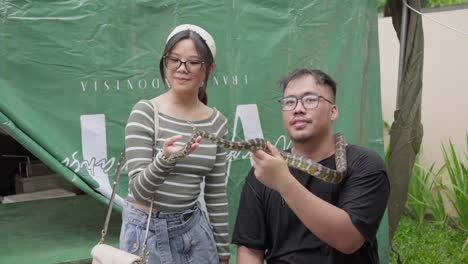 Girl-and-a-man-play-with-a-snake-in-slow-motion