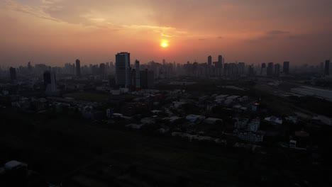 Aerial-establishing-Bangkok-skyline-bathed-in-a-golden-sunset,-Thailand