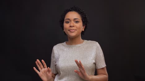 leisure-and-people-concept--happy-african-american-woman-dancing-over-black-background