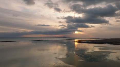 Aerial-landscape-view-over-the-Icelandic-coastline,-at-sunset,-with-a-dramatic-cloudscape