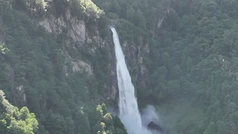 Bird's-eye-view-of-a-waterfall-with-a-large-volume-of-water-in-the-Swiss-Alps,-in-the-Vallemaggia-region,-Ticino,-Switzerland