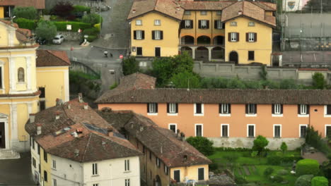 Charming-Italian-town-by-Lake-Iseo-with-historic-buildings-and-lush-greenery,-aerial-view