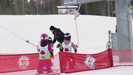 Kids-Waiting-to-Use-Ski-Lift,-Ski-Instructor-Helping-Kids-on-Ski-Lift