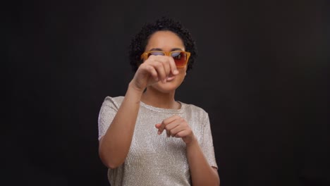 Concepto-De-Ocio-Y-Gente-Feliz-Mujer-Afroamericana-Con-Gafas-De-Sol-Bailando-Sobre-Fondo-Negro