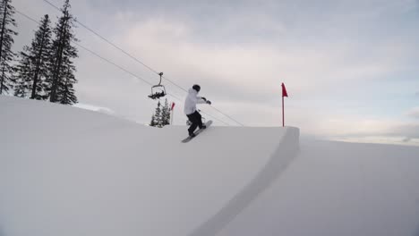 Snowboarder-Macht-Einen-360-Und-Einen-Blackflip-Auf-Mittelgroßen-Sprüngen-Im-Snowpark