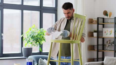 Man-Applying-Solvent-to-Rag-and-Cleaning-Old-Chair