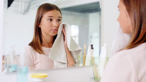 Schönheit,-Hygiene-Und-Menschen-Konzept-Teenager-Mädchen-Wischt-Ihr-Gesicht-Mit-Handtuch-Und-Blick-In-Den-Spiegel-Im-Badezimmer