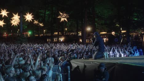 Hans-Philip-from-Ukendt-Kunstner,-performing-at-Skanderborg-festival-in-Denmark,-in-front-of-a-large-crowd