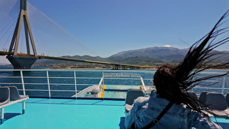 Attractive-brunette-enjoys-views-of-RIO-bridge-from-sailing-vessel,-motion-view