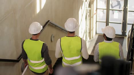 Architekten-Mit-Helmen-Gehen-Im-Büro-Die-Treppe-Hinunter